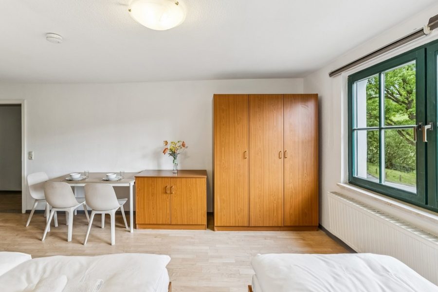 Zweibettzimmer mit Essplatz und Kleiderschrank im Gasthof Deutsche Eiche
